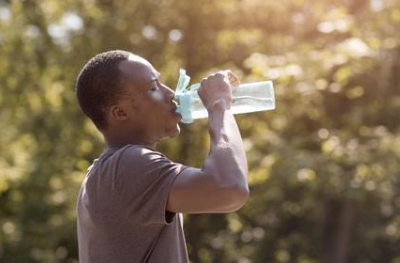 A man drinking water from a bottle outside